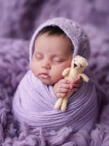 This little one is snuggling a tiny teddy bear while wrapped in a lavender swaddle. I use small, safe props to add a sweet and personal touch.