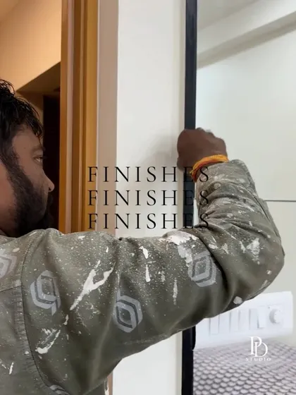 It's all about the finishes. A worker carefully installs a black metal trim, a small detail that will give the final design a sharp, modern edge.