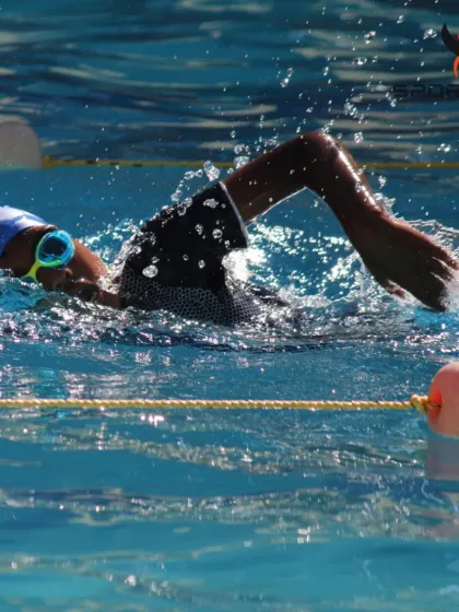An action shot of a swimmer mid-stroke, showcasing the power and focus required for competitive swimming. We help our students channel their energy into effective movement.