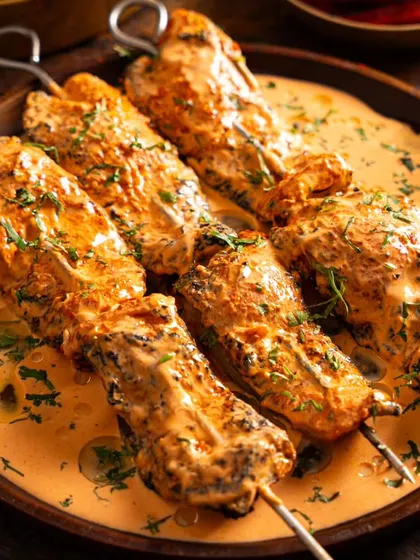 Skewers of creamy chicken malai tikka from Sadak Chaap. The close-up shot highlights the succulent texture of the chicken and the rich sauce.