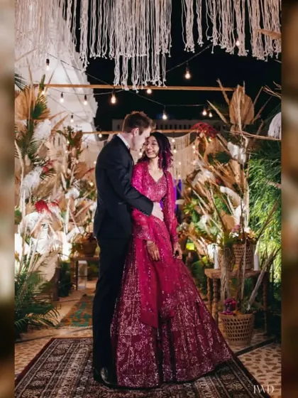 A cozy moment during a "Desert Spice" themed Sangeet. The couple is framed by bohemian decor featuring pampas grass and macrame, creating a warm and intimate atmosphere for their evening celebration.