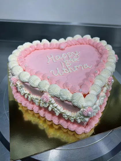 Retro cakes are so much fun! This heart-shaped cake in shades of pink and white features beautiful, detailed piping work that gives it a classic, romantic feel.