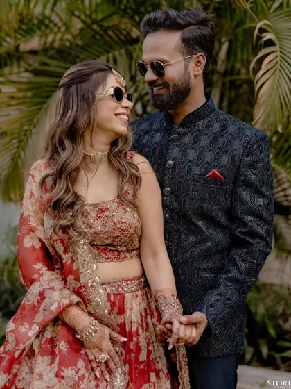 A stylish couple portrait with a modern twist. The bride's sunglasses add a touch of fun and personality to their traditional engagement attire.