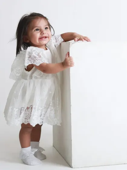 A joyful smile from a little girl who has just learned to stand. A proud milestone moment captured in a simple, elegant style.