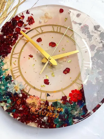 This clock is a beautiful mix of colors and textures. The preserved hydrangeas, roses, and other flowers create a stunning floral border on a clear resin base.