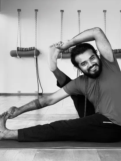 A smiling shot while holding a deep, challenging yoga posture.