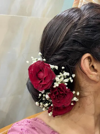 A close-up of the side placement of the roses in this elegant bridal bun.