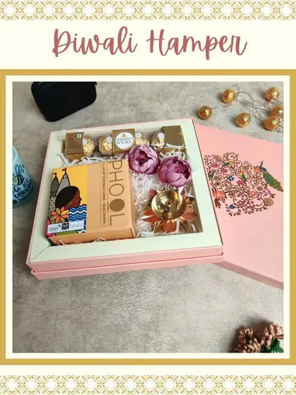 A classic Diwali hamper featuring a box of Phool incense cones, Ferrero Rocher chocolates, and a brass diya, all beautifully arranged in a window box with a traditional peacock design.
