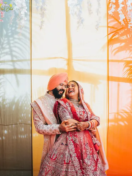 A joyful portrait of the couple against a colorful backdrop. Their infectious laughter makes this a vibrant and happy memory from their wedding day.