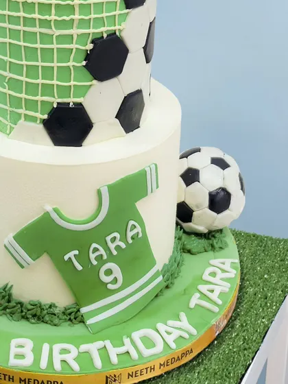 A close-up of the football cake, showing the personalized jersey and edible grass texture.
