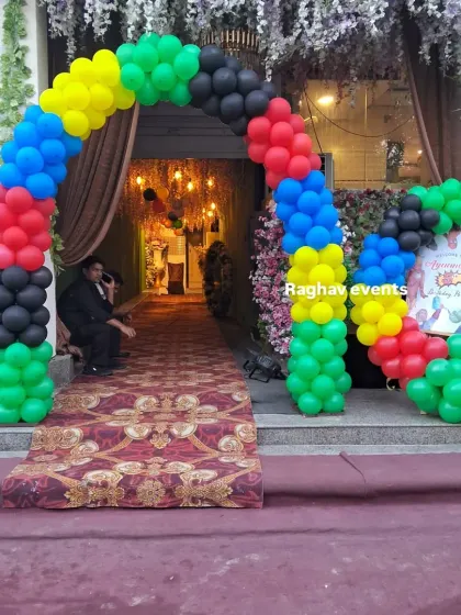 A colorful balloon arch in green, yellow, red, blue, and black, perfect for a fun and vibrant party entrance.