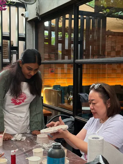 An instructor showing a participant how to perfect her Jesmonite piece at the Lam Research workshop.