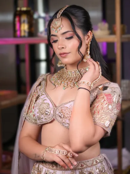 Elegance is in the details. This side profile showcases the delicate hairstyle and how the makeup enhances the model's features without overpowering them.