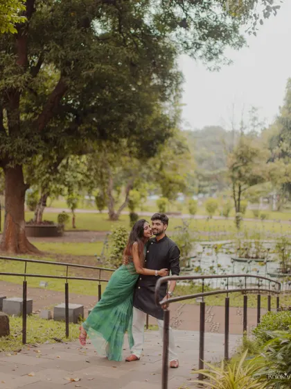 A sweet embrace on a bridge in a park, capturing a spontaneous and affectionate moment.
