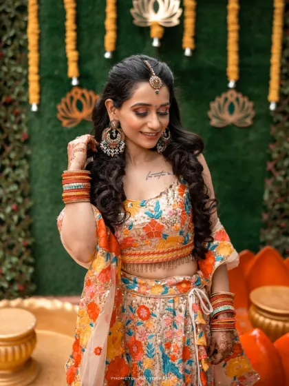 The bride looks radiant in her floral lehenga, her smile capturing the excitement of the Haldi function.