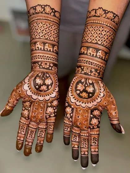 A stunning engagement mehendi with lotus and elephant motifs, featuring a mix of bold and fine lines.