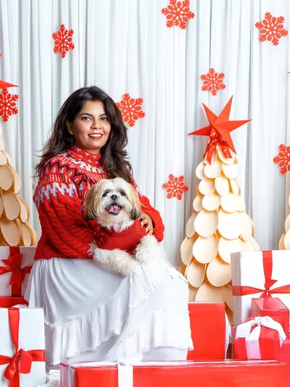 This stylish duo is perfectly coordinated in red and white for their Christmas portrait. The fluffy Shih Tzu looks like a little holiday angel in its mom's arms.