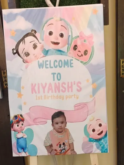 A personalized welcome easel sign for a Cocomelon themed first birthday party, featuring a photo of the birthday boy.
