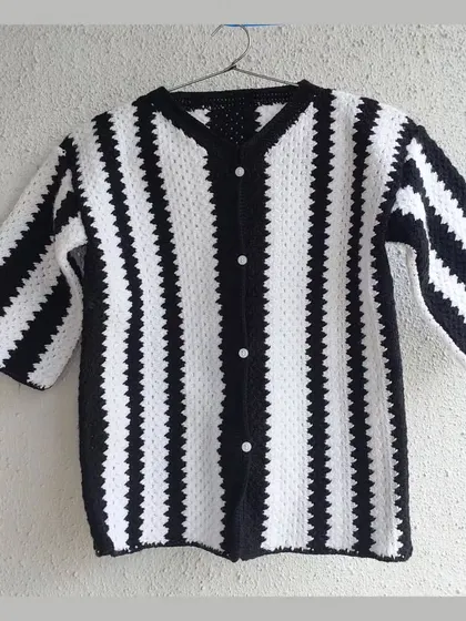 A classic black and white striped shirt, custom-made with a V-neck and button-front. This is a timeless piece that can be styled in countless ways.