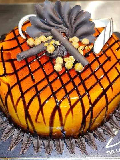 A delicious chocolate butterscotch cake. This cake features a crunchy butterscotch topping over a rich orange glaze with a chocolate lattice pattern.
