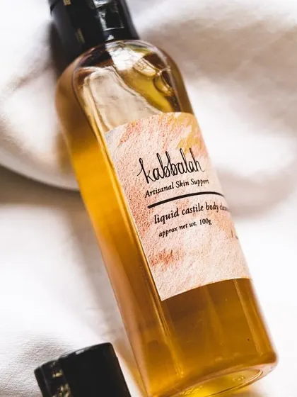 A close-up of the cleanser bottle, highlighting the simple, artisanal label.