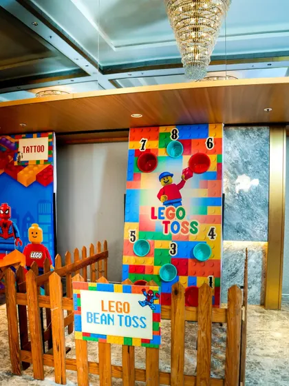 A LEGO-themed bean toss game, where players aim to throw bean bags into numbered holes on a colorful board.