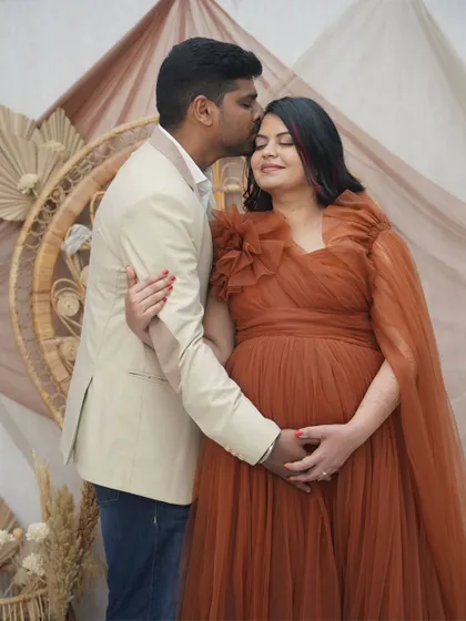 A tender moment between the parents-to-be. Her makeup is soft and romantic, with a focus on glowing skin and defined eyes, perfectly matching the bohemian-themed shoot.