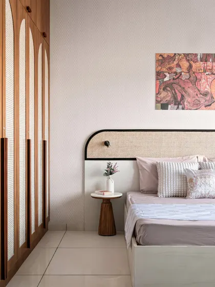 A closer look at the Japandi-inspired bedroom, highlighting the custom headboard with a black accent frame and the minimalist wooden side table. The abstract art adds a touch of modern personality.