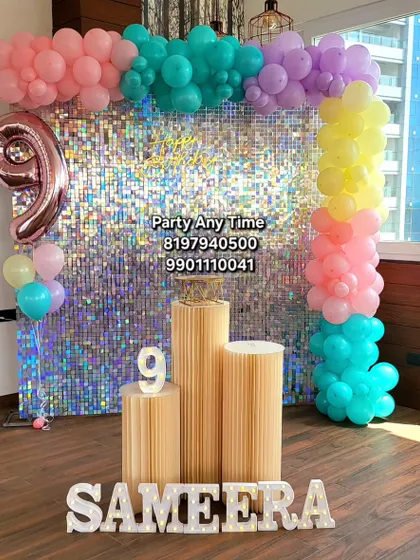 A 9th birthday setup featuring a silver shimmer wall, colorful pastel balloons, and light-up marquee letters, all available for rent.