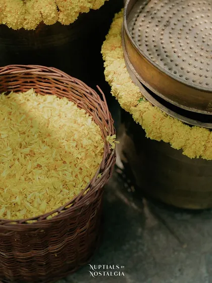 A basket of 'Akshata' (turmeric-coated rice) ready for the rituals, an essential and symbolic element of the ceremony.