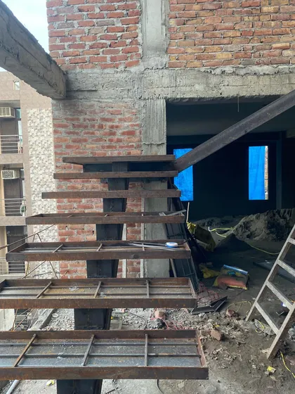 The raw metal framework of a cantilevered staircase during construction. This shows the essential structural engineering that underpins the minimalist final design.