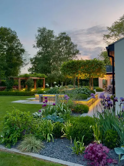 This garden is designed for evening enjoyment with layered lighting. We installed uplighting on trees, strip lighting under benches, and soft lights within the flower beds to create depth and highlight key features after sunset.