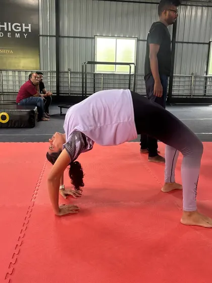 A participant in our workshop practices her backbend, a key focus of our flexibility training.