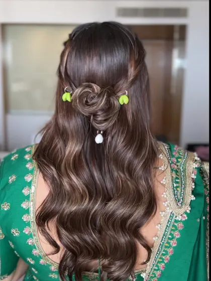 A back view of the half-updo for Dandiya night, featuring a rose-shaped bun and shell accessories for a unique, festive touch.