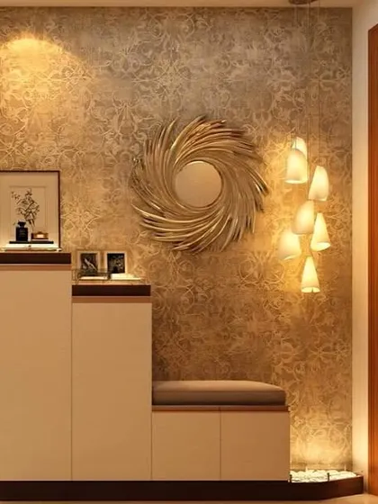 An elegant foyer area with a unique textured wall, a gold sunburst mirror, and a cozy seating bench with shoe storage.