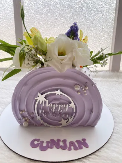 Another view of the lilac top-forward cake. The silver "Happy Birthday" charm adds a modern touch to the floral design.