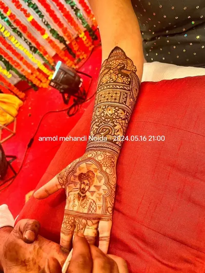 A close-up of a groom's portrait being meticulously applied on the bride's palm, showcasing the precision and skill involved in my portrait work.