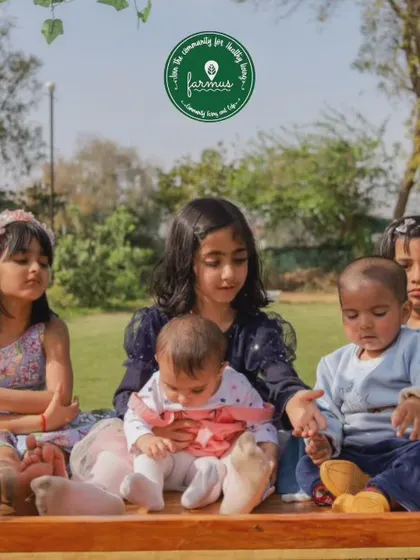 A sweet moment with a group of children sitting together on a wooden swing, enjoying the peaceful atmosphere of a farm birthday.