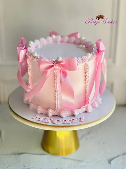 A pretty pink bow cake for a 21st birthday. This design features soft pink frosting and is decorated with delicate satin-like ribbons.