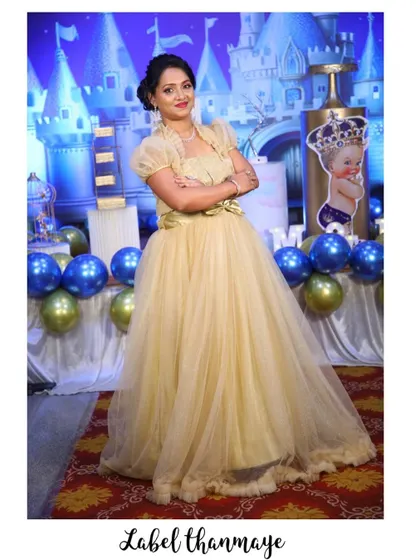 The mother from the family set, looking elegant in her custom golden gown with puffed sleeves.