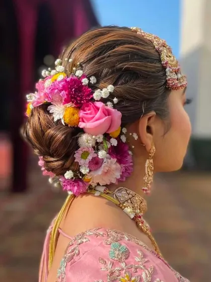 A vibrant and full floral bun using a variety of colorful flowers, ideal for a festive bridal look.