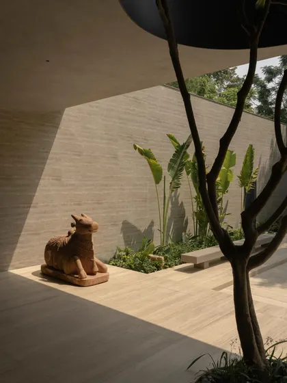 The integration of nature is a key theme, seen in the voids cut for trees and the placement of art and sculpture in the garden. The architecture frames and celebrates the natural environment.