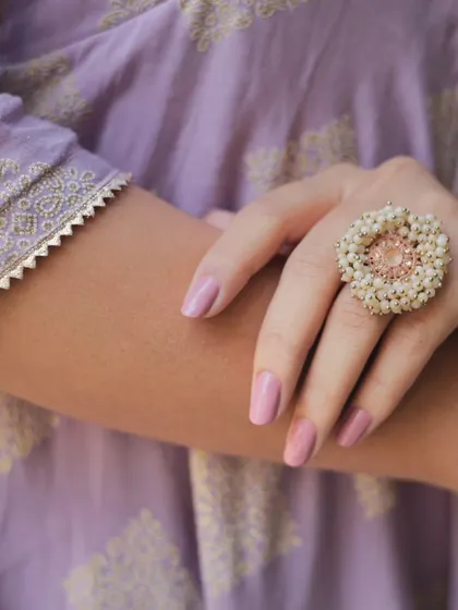 An extreme close-up on the statement ring and the sleeve detail, perfect for highlighting accessories in a commercial shoot.