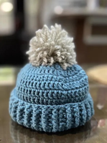 This is another one of my baby beanies, this time with a soft, neutral-colored pom-pom. I use a ribbed stitch for the brim to make sure it's extra stretchy and comfortable for the baby.
