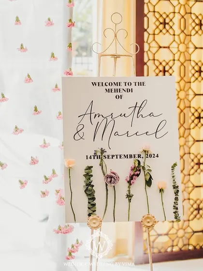 A closer look at the details from a pastel Mehendi. We used delicate floral arrangements, custom welcome signs, and sheer curtains with tiny flowers to create a soft and romantic atmosphere.