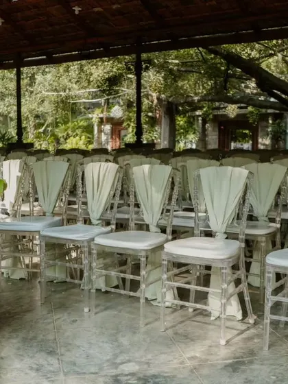 The clean lines of the clear chairs and the soft drape of the sashes create a look that is both modern and romantic.