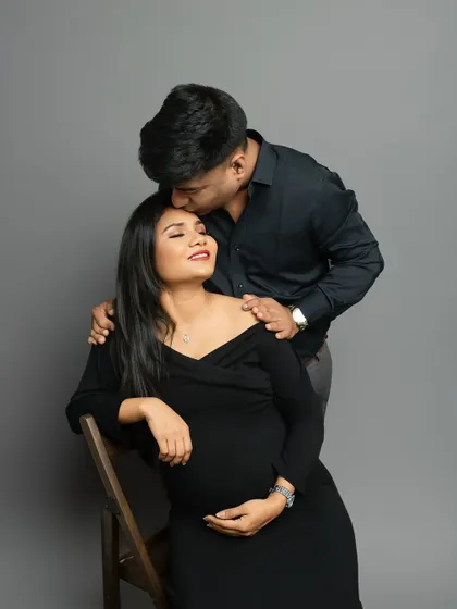 A classic pose of love and affection. The partner's gentle kiss on the forehead is a timeless symbol of care and devotion during this special journey.