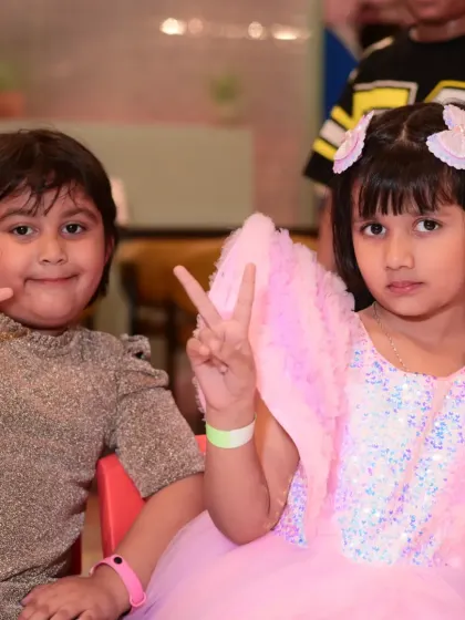 Two friends making peace signs for the camera, enjoying the party together.