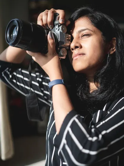 A self-portrait taken during a shoot, capturing a moment of creative focus in the warm sunlight.