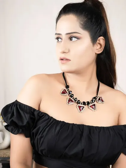 A model wearing a statement necklace with bold geometric stones. I use posing and lighting to showcase how the jewellery complements an outfit.